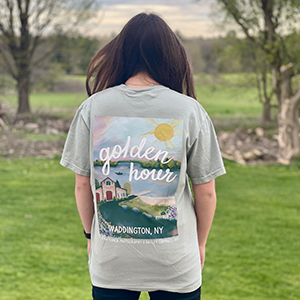 High School student Rileigh Stebbins models a Golden Hour t-shirt while standing in a forest.