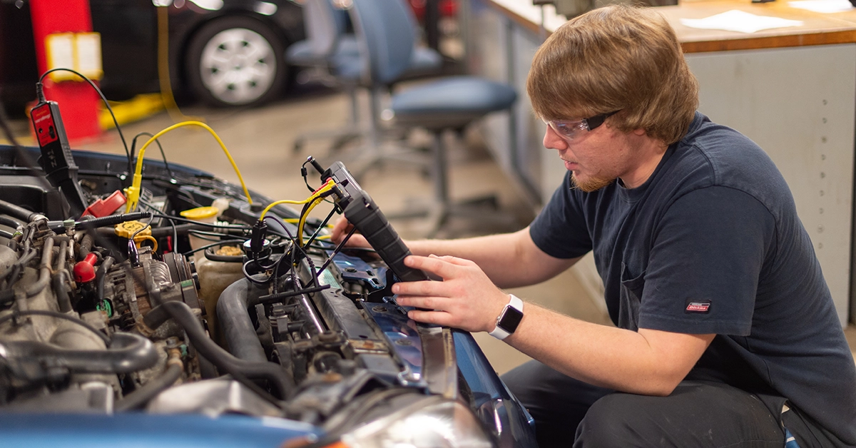 A student diagnoses a car in the Automotive lab.