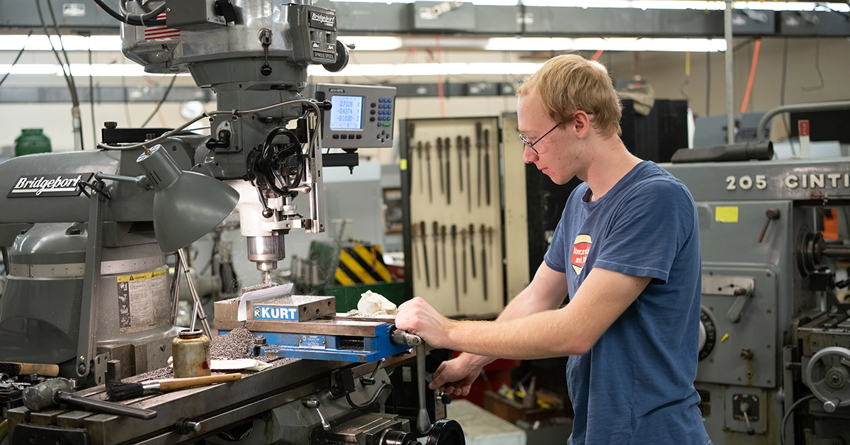 A student uses a drill press in the Mechanical Technology lab.
