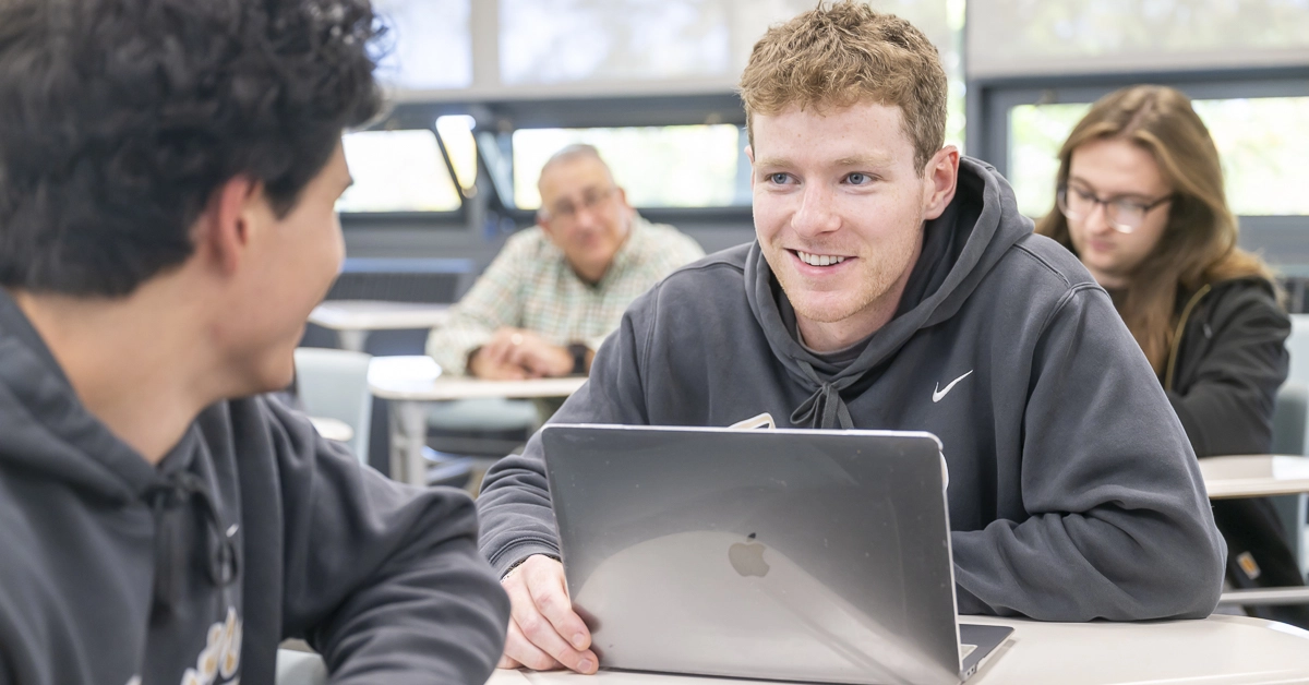Two students work on a group marketing plan in class.