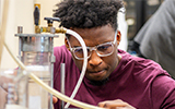 A Civil Engineering Technology student works on water filtration.