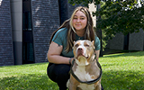 A student poses with her dog outside Mohawk Hall.