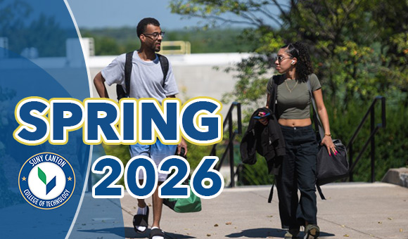 Spring 2026: Two students walk on the sidewalk next to Payson Hall.