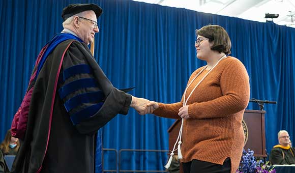 A students shakes President Szafran's hand at Honors Convocation 2023.