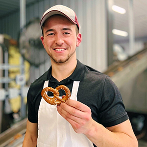 Josiah Martin holds up a hand-crafted pretzel.