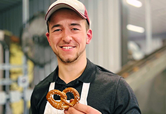 Josiah Martin holds up a hand-crafted pretzel.