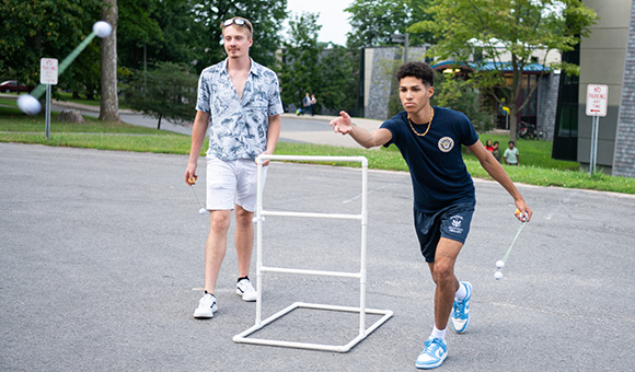 Two students play ladder ball outside of the residence halls.