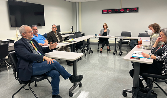 SUNY University Faculty Senate President Keith Landa meets with SUNY Canton faculty in the Financial Literacy Center.