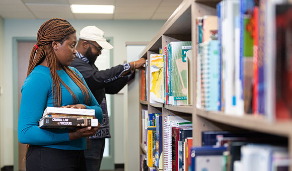 Two students browsing for books in the library.