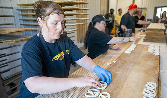 Employees twist pretzels into their iconic shapes prior to baking at Martin's Pretzel company.