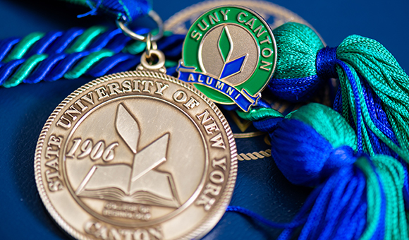 Grad medallion and SUNY Canton Alumni pin