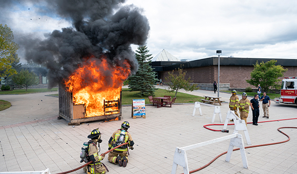 Firefighters line up to extinguish a mock burn in the Roselle Plaza.