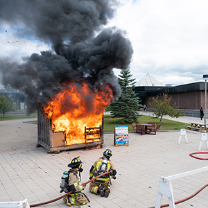 Firefighters line up to extinguish a mock burn in the Roselle Plaza.