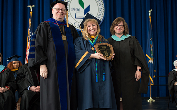 Outstanding Graduate Jamie Reed receives her award from President Szafran and VP Courtney Bish