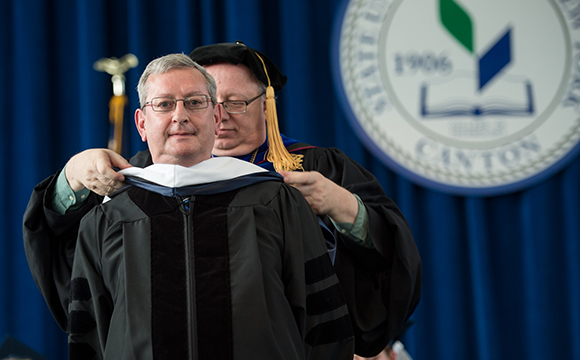 John Maines receives his doctoral hood from President Szafran