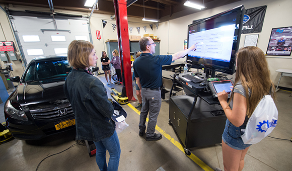 Brandon Baldwin uses a touch screen to instruct a small group of students.