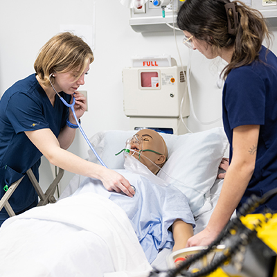 Two nursing students check vitals in the Mary Caswell Nursing Simulation lab.