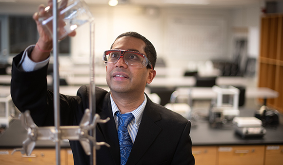 Rajiv Narula pours liquid into a test tube.
