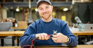A non-traditional student connects wires in the electrical tech lab.