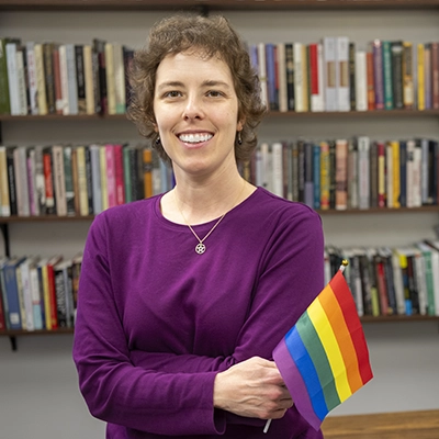 Emily Hamilton-Honey holds a LGBTQ flag.