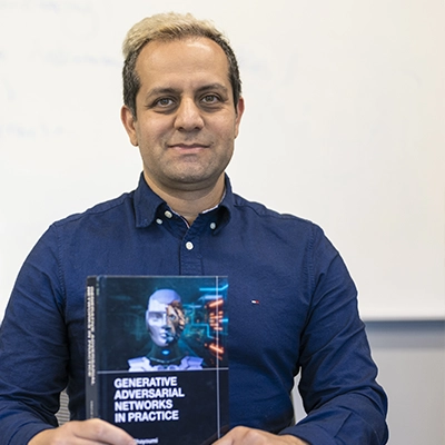 Mehdi Ghayoumi holds his book titled Generative Adversarial Networks in Practice.