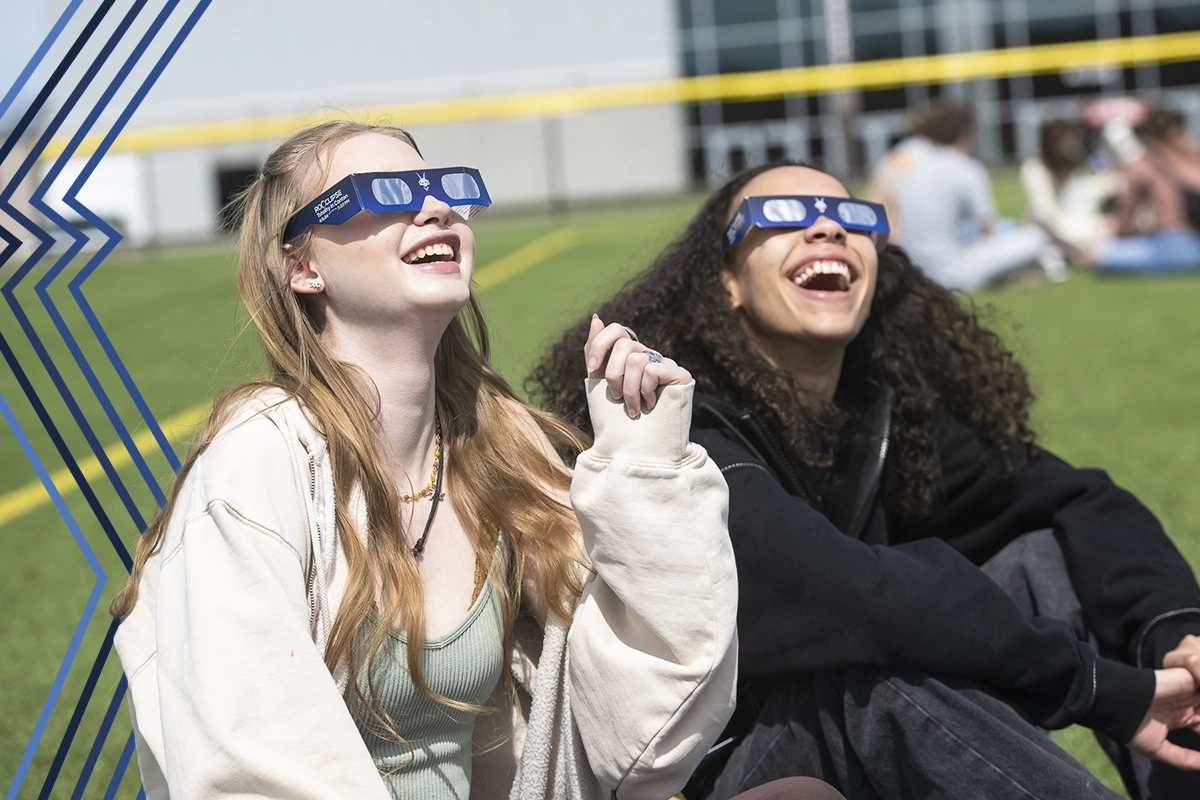 Two students look up at the sky with safety glasses during the recent solar eclipse.