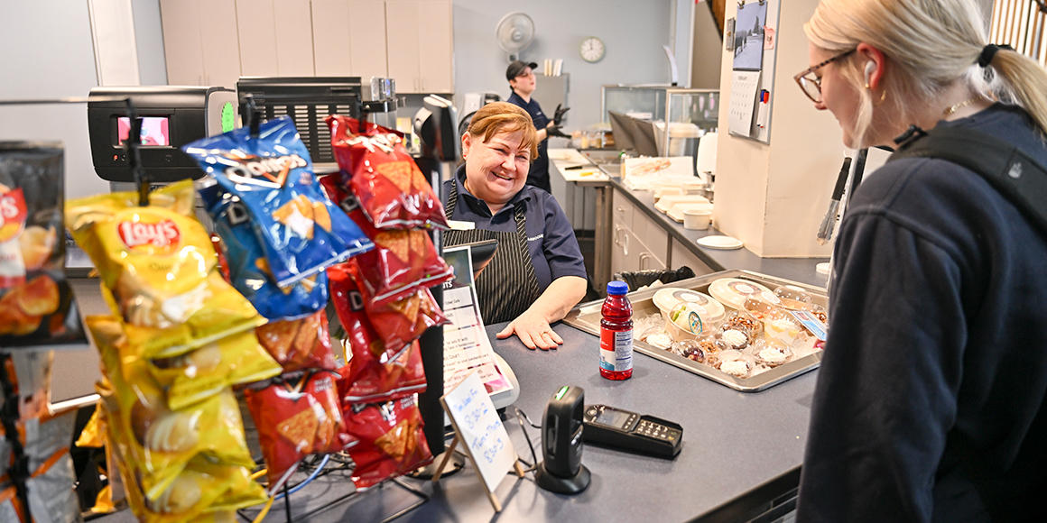 A dining associate cashes out a student at Roos Court.
