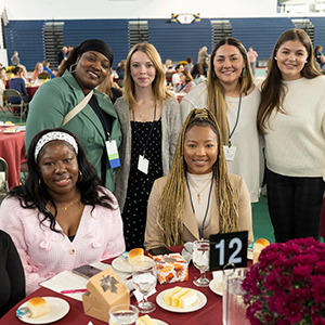 Students and donors happily gathered around a round table at Scholarship Luncheon 2024.