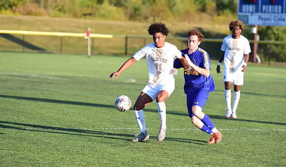 Markel Mosley holds off a defender during a soccer match against SUNY Poly.