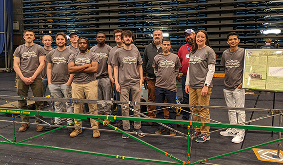 SUNY Canton ASCE Chapter pose with steel bridge.