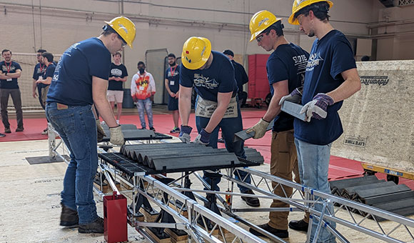 Students build SUNY Canton's steel bridge during regional competition.