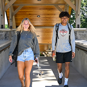 Two students use the new covered walkways on campus.