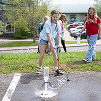 A middle school camper detonates a water filled bottle rocket from a parking lot.