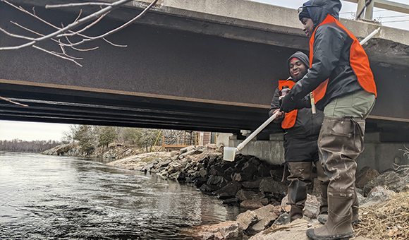 Yusuf Jabbie and Ladonna Smith collect water samples from Black Lake.