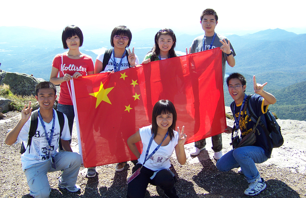 Chinese students hold a flag on top of Whiteface Mountain