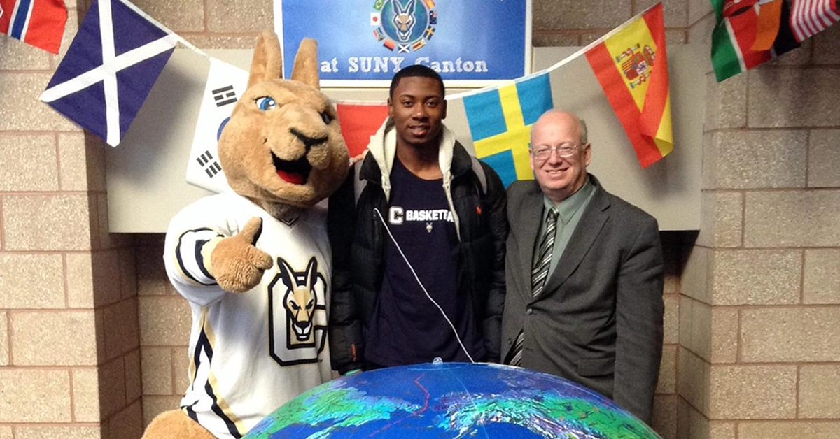 Roody, an international student, and President Szafran pose next to a giant inflatable globe.