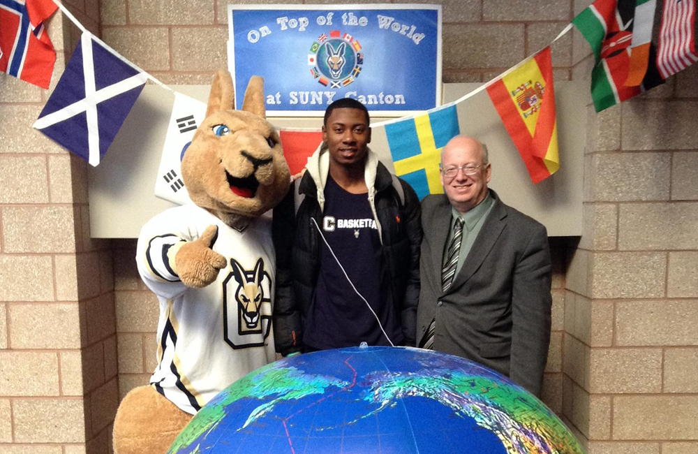 President Szafran and Roody stand with a student in front of a giant globe